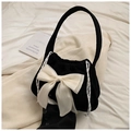 Close-up of black corduroy handbag featuring a large cream silk bow and drawstring details - Black