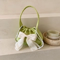 Light green corduroy handbag featuring a large white bow and drawstring closure - Green
