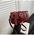 Detalle de bolso bandolera de cuero granate con hebillas y cremalleras laterales - Fucsia