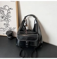 Detail eines schwarzen Lackleder-Hobo-Rucksacks mit Glanzeffekt und Quastenanhänger - Schwarz