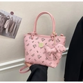 Detailed view of a pink monogrammed bucket bag featuring cartoon prints and bow charm - Pink Style (With Charm)