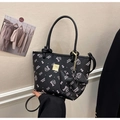 Close-up of black leather bucket bag with pink cartoon kitten prints and gold hardware - Black Style (With Charm)
