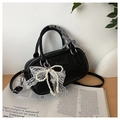 Close-up of black bowling bag with pearl lace bow charm and ribbon wrapped handle - Black