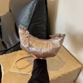 Detalle del bolso croissant oro rosa con textura metálica plisada y asa con nudo - Rosa