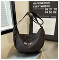 Détail du sac hobo en nylon noir avec texte MANWU sur une surface métallique - Noir