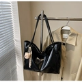 Dettaglio della borsa tote nera lucida con ciondolo a orsetto e nappina intrecciata - Nero (Con Ciondolo)