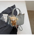 Borsa a secchiello grigio-blu chiaro con trama litchi, ciondolo orso e chiusura oro - Con Ciondolo / Azzurro