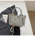 Borsa a mano azzurra trama litchi con chiusura dorata e tracolla in un ambiente urbano chic - Senza Ciondolo / Azzurro