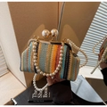 Detail of colorful woven straw bag featuring pearl strap and vintage clasp closure - Colorful