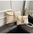 Comparison of two sizes for the cream white faux leather crossbody bag with woven buckle - Large / White