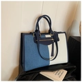Detalle del bolso tote de lona y mezclilla con ribete de cuero azul y borlas largas - Azul claro