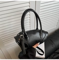 Close-up of black leather bowling bag with silver buckle straps and smooth texture - Black