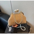 Detail of hand-woven straw evening clutch featuring large pearl clasps and beaded handle - Khaki