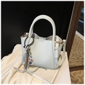 Detail of light grey lychee leather handbag with adjustable strap and bear charm - Blue (With Pendant)