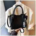 Detail of black pebble leather bucket bag with fashion logo and bear charm accessory - Black (With Pendant)