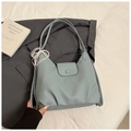 Detalle del bolso hobo azul claro con textura lichi y colgante de lazo de encaje y perlas - Azul con Colgante