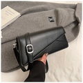 Detalle de bolso geométrico de cuero negro con hebilla plateada y diseño moderno elegante - Negro