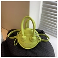 Detail of neon green round mini bag with lychee texture and circular handle - Green