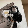 Chic black patent leather boston bag with pearl lace bow charm and crossbody strap - Black