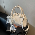 Chic beige leather Boston handbag with elegant lace pearl bow decoration and shoulder strap - White