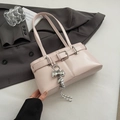 Pink faux leather shoulder bag with silver bow charm and elegant woven rope detail - With Pendant / Pink
