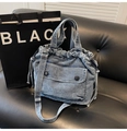 Detalle de bolso de mezclilla azul con bolsillos frontales y cordones ajustables - Azul claro