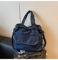 Detalle del bolso vaquero azul con cierre de cordón y bolsillo frontal con hebillas - Azul marino