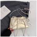 Close-up of elegant cream bow decoration and pearlescent texture on the shoulder bag - White with Pendant