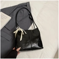 Nahaufnahme der schwarzen Leder-Tasche mit elegantem Perlen- und Spitzenanhänger - Schwarz mit Anhänger