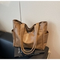 Close-up of brown PU leather tote bag featuring side pockets and a metal snap button detail - Coffee