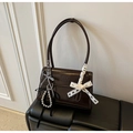 Detail of dark brown patent leather shoulder bag with chic ribbon and bead accessories - Coffee with Pendant