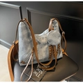 Détail du sac cabas en jean bleu avec lanières en cuir brun et patch M riveté - Bleu Denim