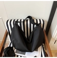 Detalle de bolso medialuna de nailon negro en silla de rayas con correa ancha ajustable - Negro