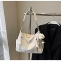 Detail of cream-colored large tote bag with vertical zipper pockets and plush pendant - Off-white