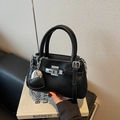 Chic black pebble leather bucket bag with silver twist lock and heart chain charm - Black