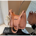 Detailed shot of pink leather bucket bag with gold label and pearl bow pendant decoration - With Pearl Lace Bow Charm / Pink