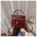Detail van donkerrode gewatteerde lederen vanity bag met goudkleurig handvat en bloem - Bordeauxrood
