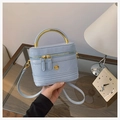 Detail van lichtblauwe gewatteerde box-tas met gouden bloemlogo en metalen handvat - Blauw