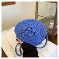 Detailed macro view of handcrafted blue rose crochet pattern on a woven shoulder bag - Blue