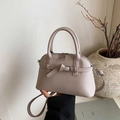 Detail of elegant beige shell bag with lychee grain leather and decorative strap buckle - Gray