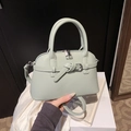 Detail of mint green lychee grain leather handbag with silver hardware and top handles - Green