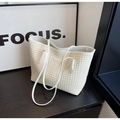 Close-up of cream woven shoulder tote bag texture with minimalist metal label detail - Off-white