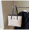 Detailed view of beige tote bag with black leather piping and metallic nameplate - No Pendant / White and Black Splicing