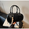 Detail der schwarzen Bowling-Tasche aus Leder mit Prägung und buntem Webanhänger - Mit Anhänger / Schwarz