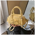 Dettaglio della borsa bowling giallo chiaro con fiocco, finitura lucida e hardware chic - Giallo