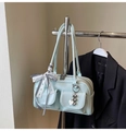 Close-up of light blue leather handbag featuring dual front pockets and heart charm - Light Blue With Pendant