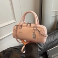 Pink cylinder crossbody bag in glossy faux leather with a silver pendant and dual handles - Pink
