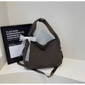 Detail of dark brown checkered hobo bag featuring a delicate white lace bow accent - Coffee