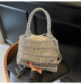 Detail der silbernen geflochtenen Tasche mit weißem Kordelzug-Inlay auf einem Stuhl - Tote Stil Eins (Silber)