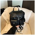 Detail of black pebble leather backpack featuring dual front pockets with metal buckles - Black